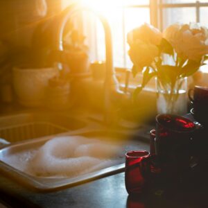 Pristine kitchen sink backlit by soft lighting. Photo by Sixteen Miles Out on Unsplash